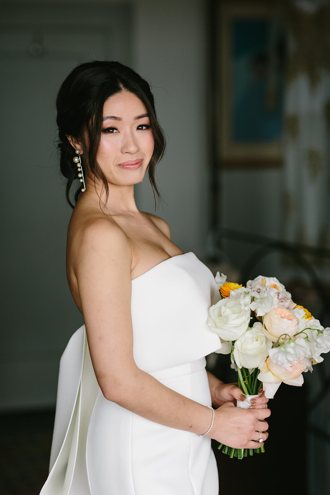 bride with bouquet with makeup and hair styled