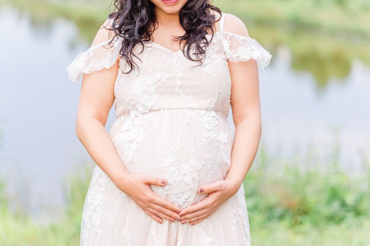 mom holding her belly during maternity photos in Burke, Virginia