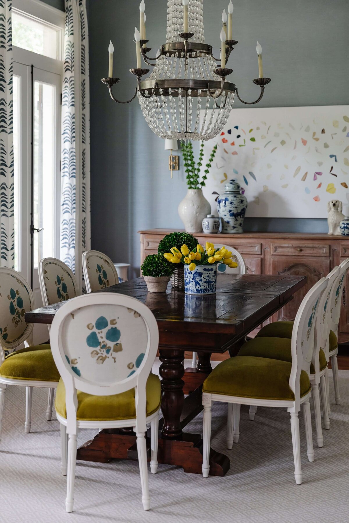oyster creek studios home on the range chandelier and wooden dining room table with white chairs with chartreuse cushions in dining room