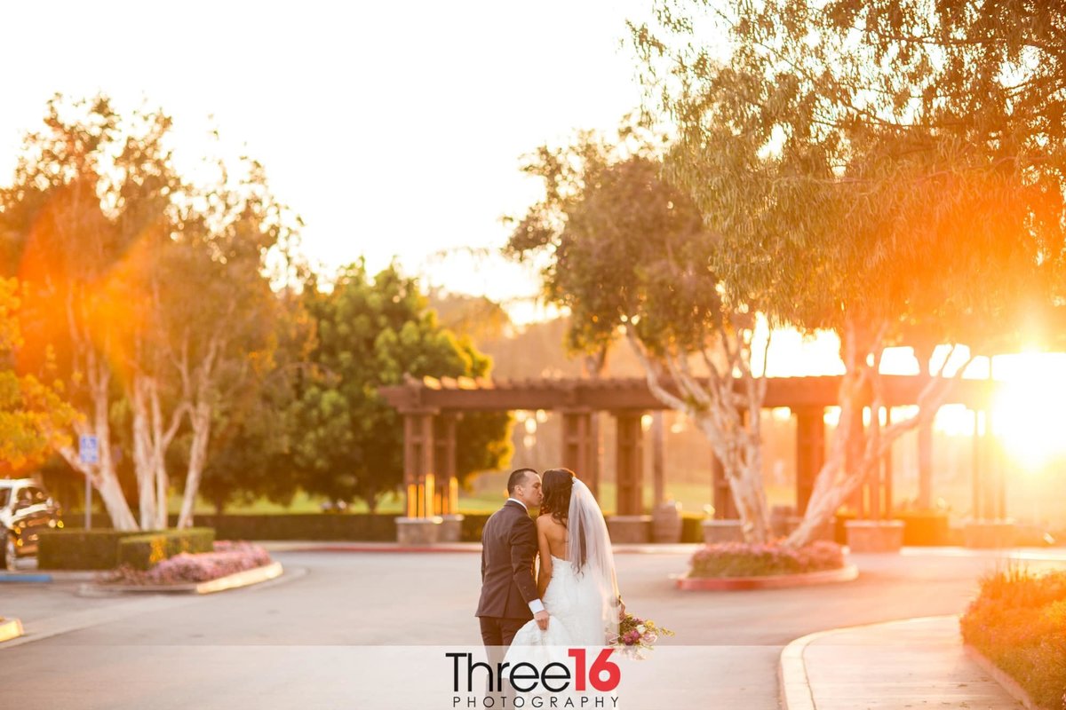 Bride and Groom share a kiss as the sun starts to set