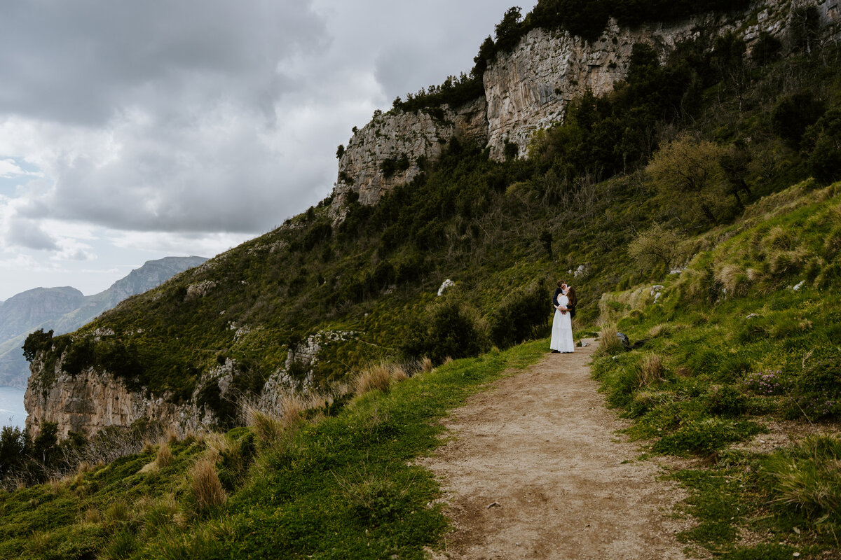 Couple walking along a rocky mountain ridge.
