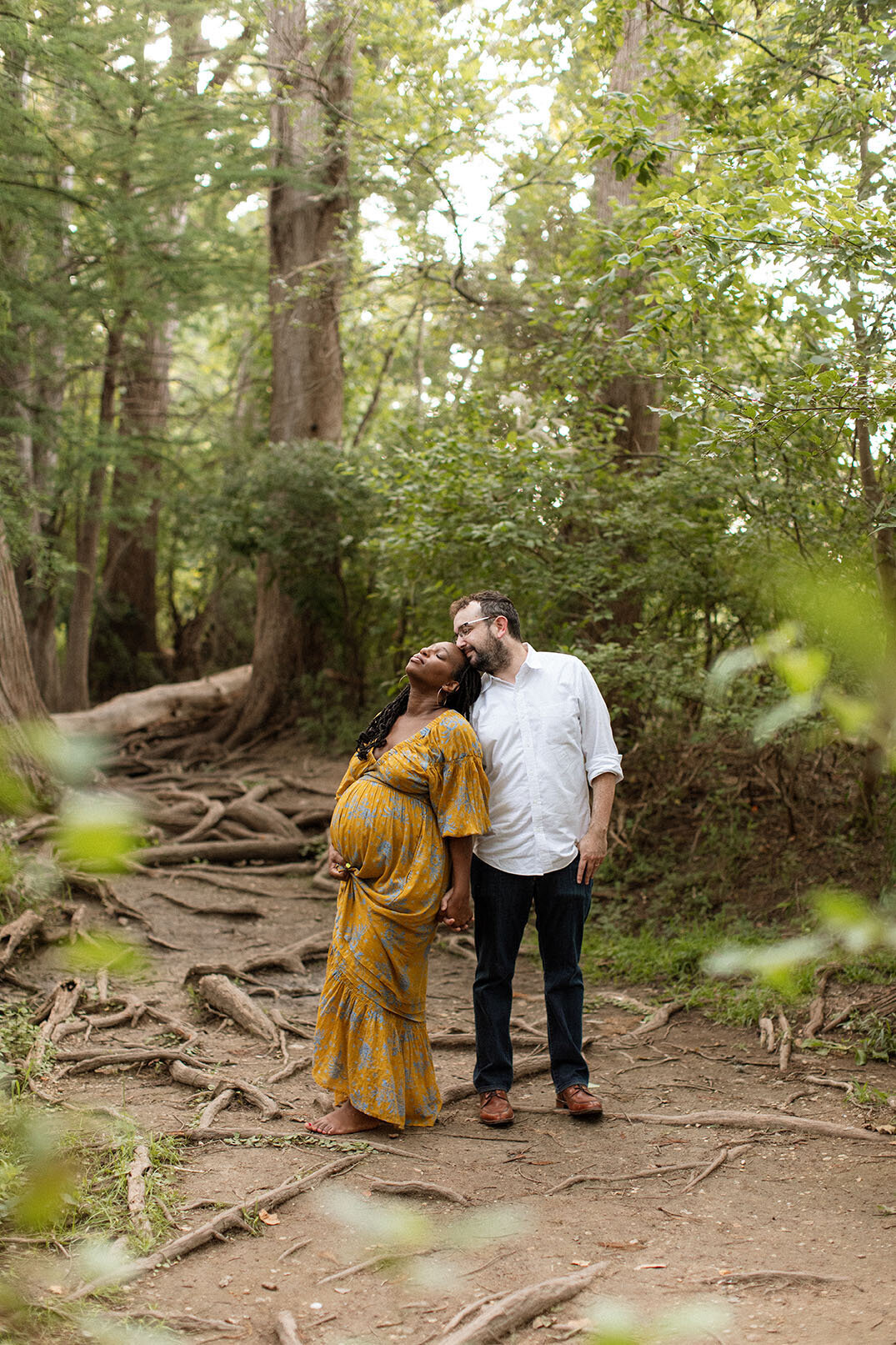 Maternity portrait of a pregnant couple standing in a natural outdoor setting, photographed by San Antonio family photographer Sara James.