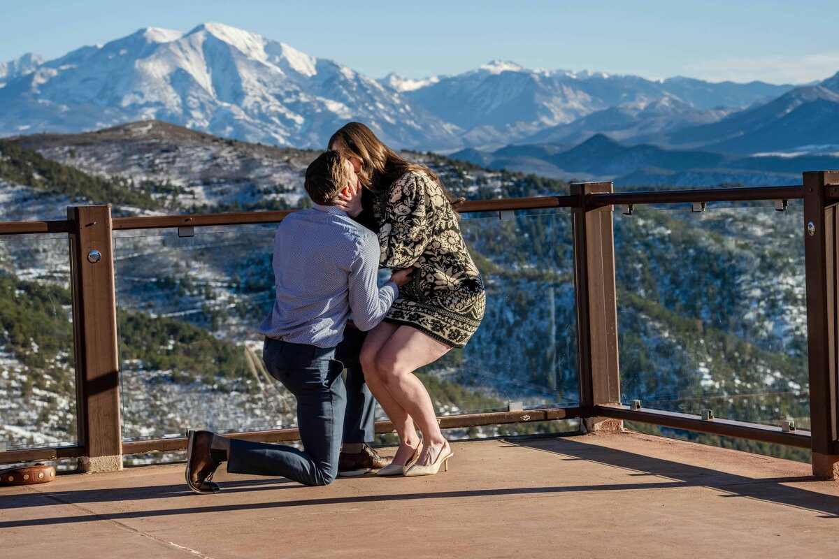 Women kissing a man on his knees proposing in Glenwood Colorado