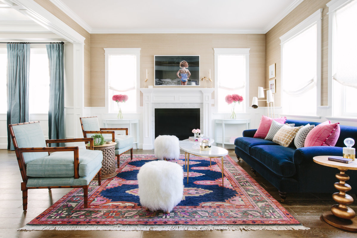 Navy and pink living room with navy velvet sofa, marble and gold coffee table, seagrass wallpaper, and caitlin Wilson Kismet  rug
