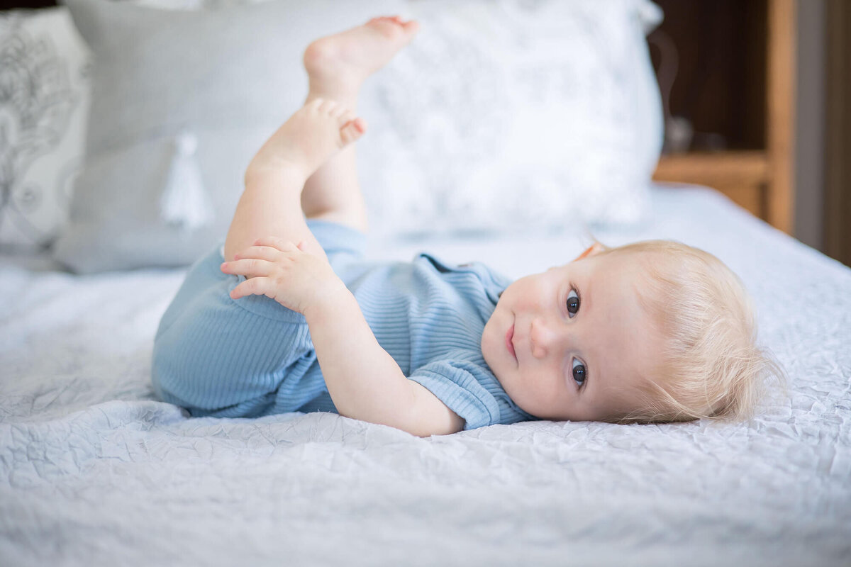 smug baby boy laying on a bed during session with las vegas milestone photographer Jessica Bowles