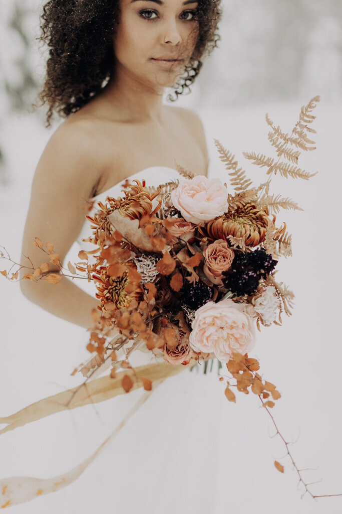 Winter inspired bridal bouquet of orange, rust, pink, and burgundy by J.A.M Florals, contemporary and playful Kelowna wedding florist, featured on the Brontë Bride Vendor Guide.