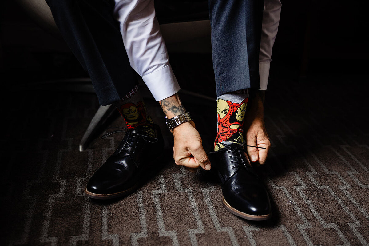 Close-up of a person's feet wearing black dress shoes and colorful comic book-themed socks