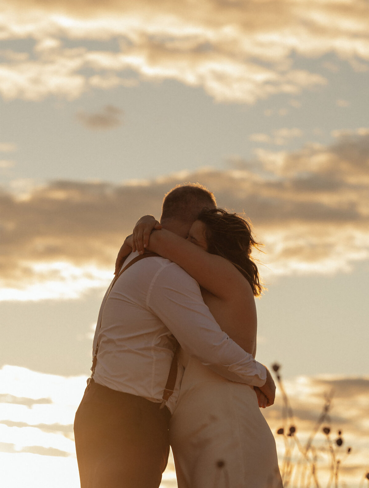 bride and groom hug each other after exchanging their vows under a glowing, sunset sky in the Dalles, Oregon