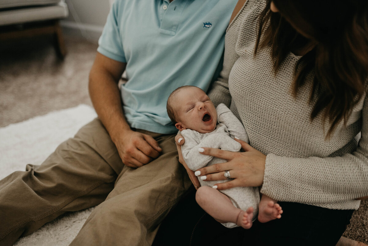 Parents holding newborn yawning
