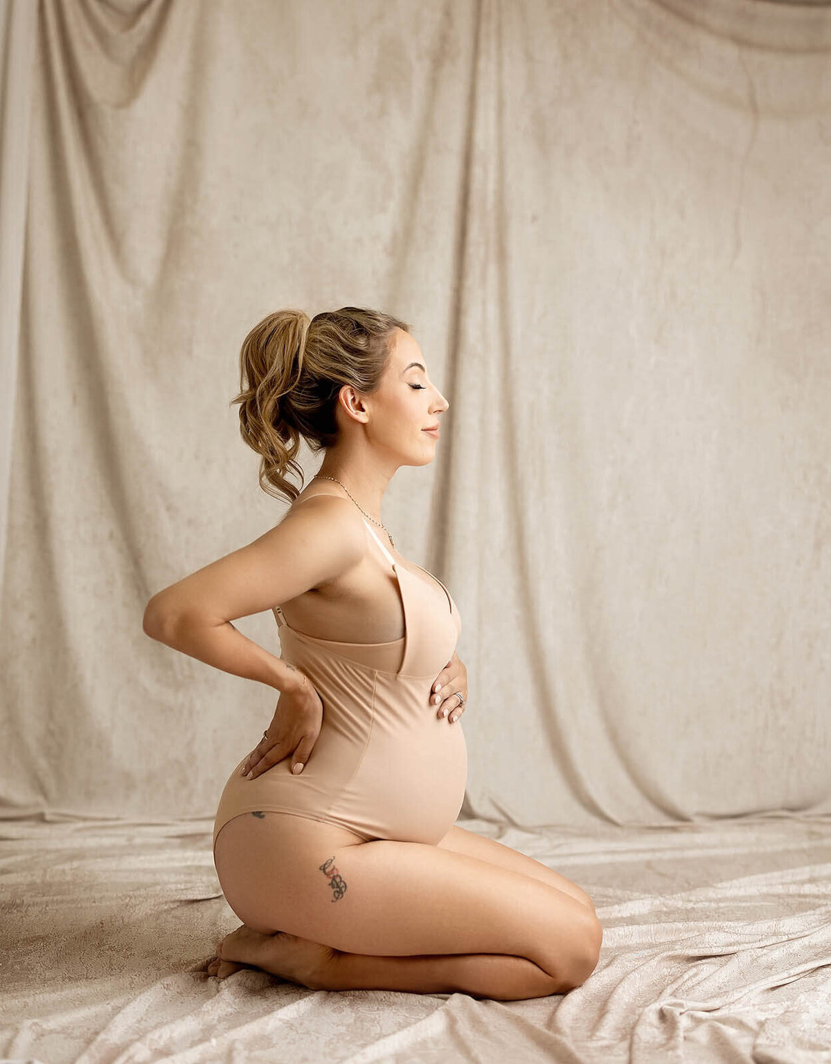 A women holds her belly in a portrait from a Vancouver photographer