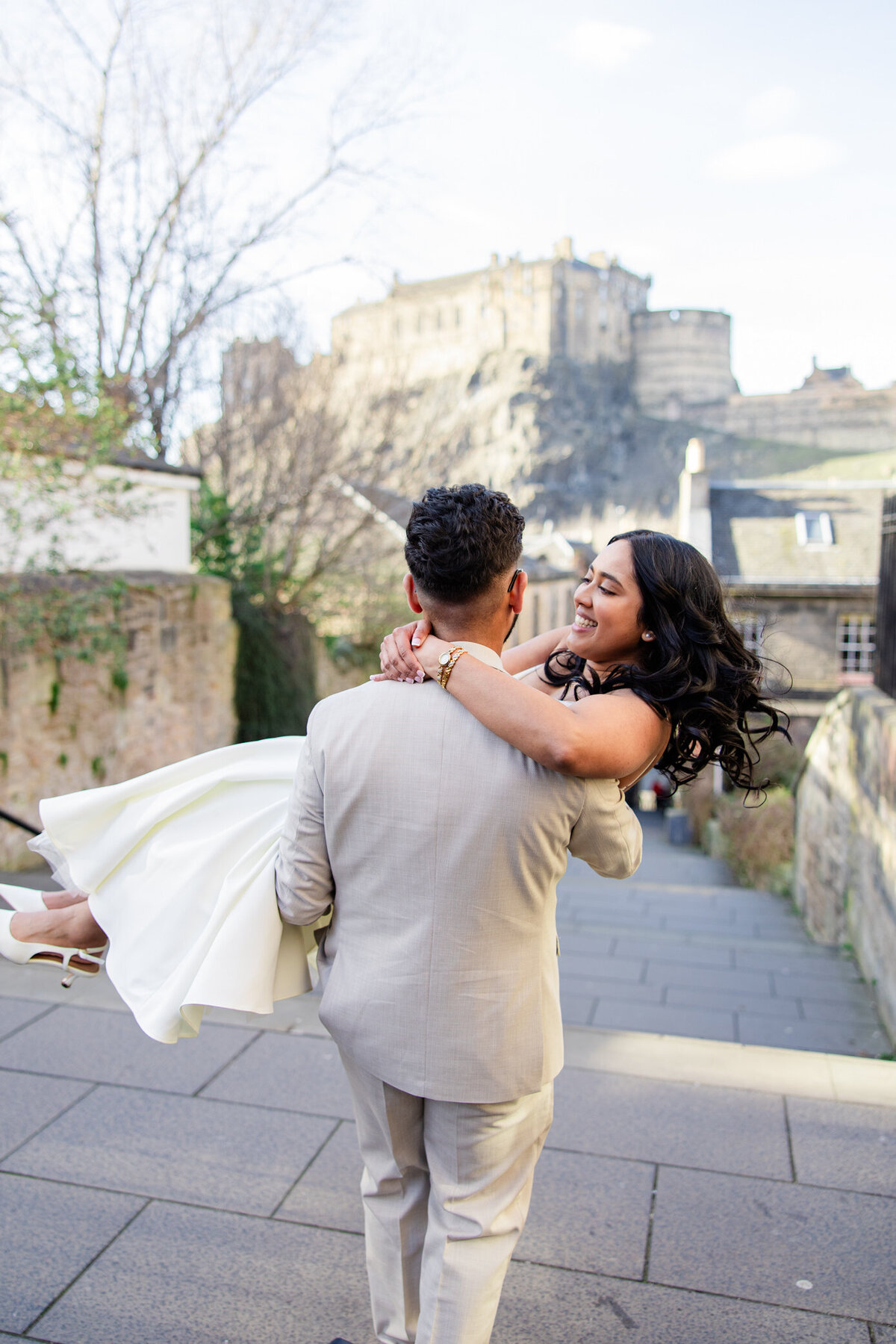 groom spins bride in front of castle