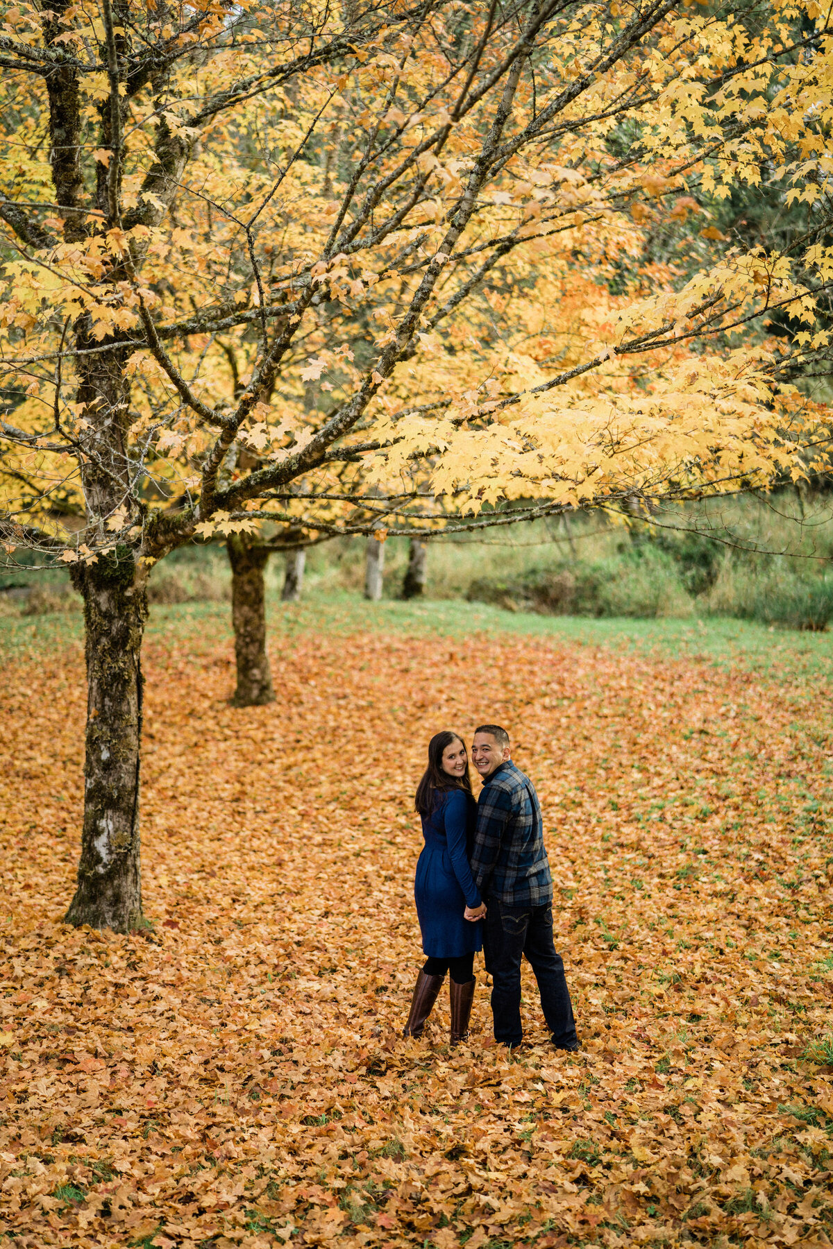 Fall leaves surround the couple at Rockwood Farm, best places for engagement photos in Seattle