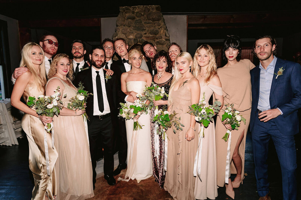 The bride and groom are together with family and friends in Foxfire Mountain House, New York. Wedding Image by Jenny Fu Studio