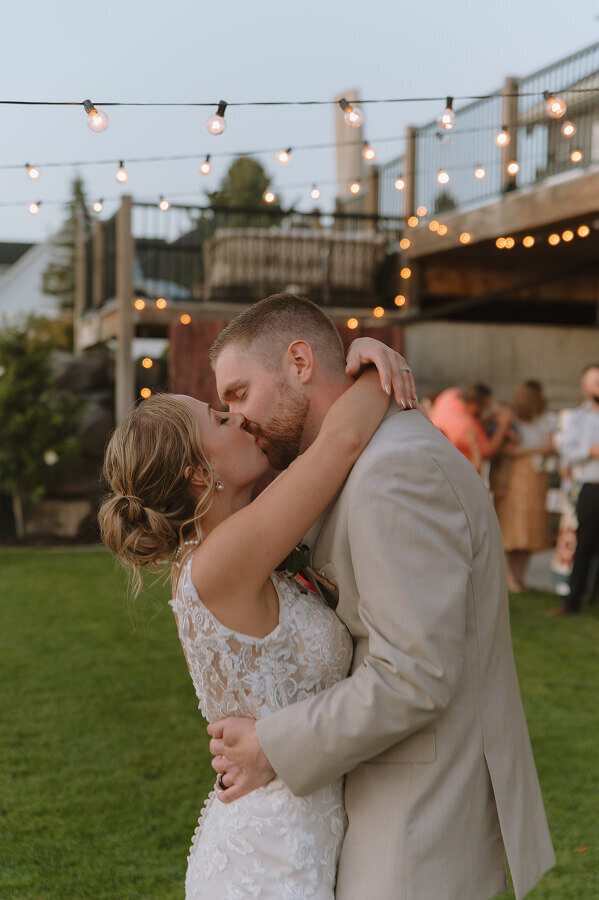 A bride and groom kiss during their first dance during their wedding reception in Swan Valley, ID.