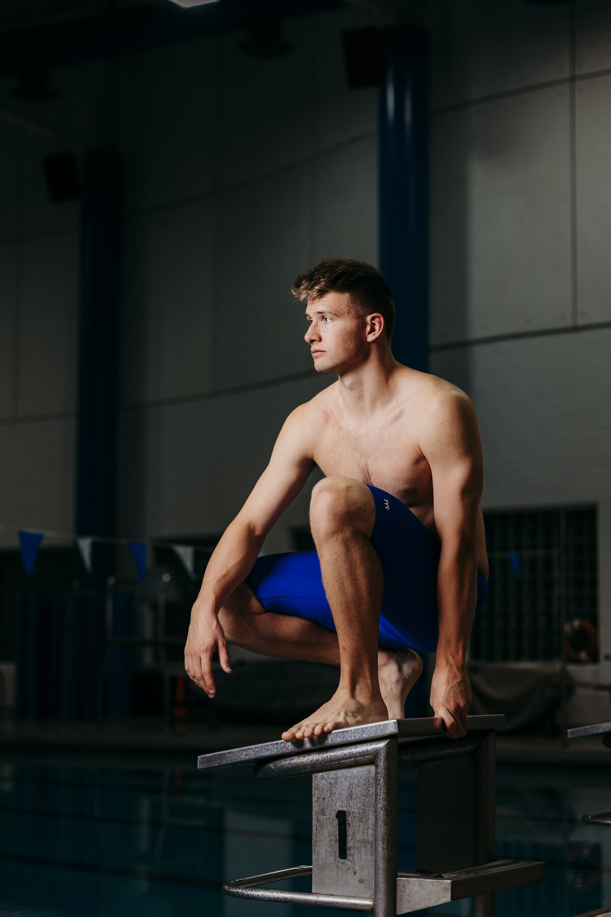 Ionia High School swimmer posing on starting blocks. 