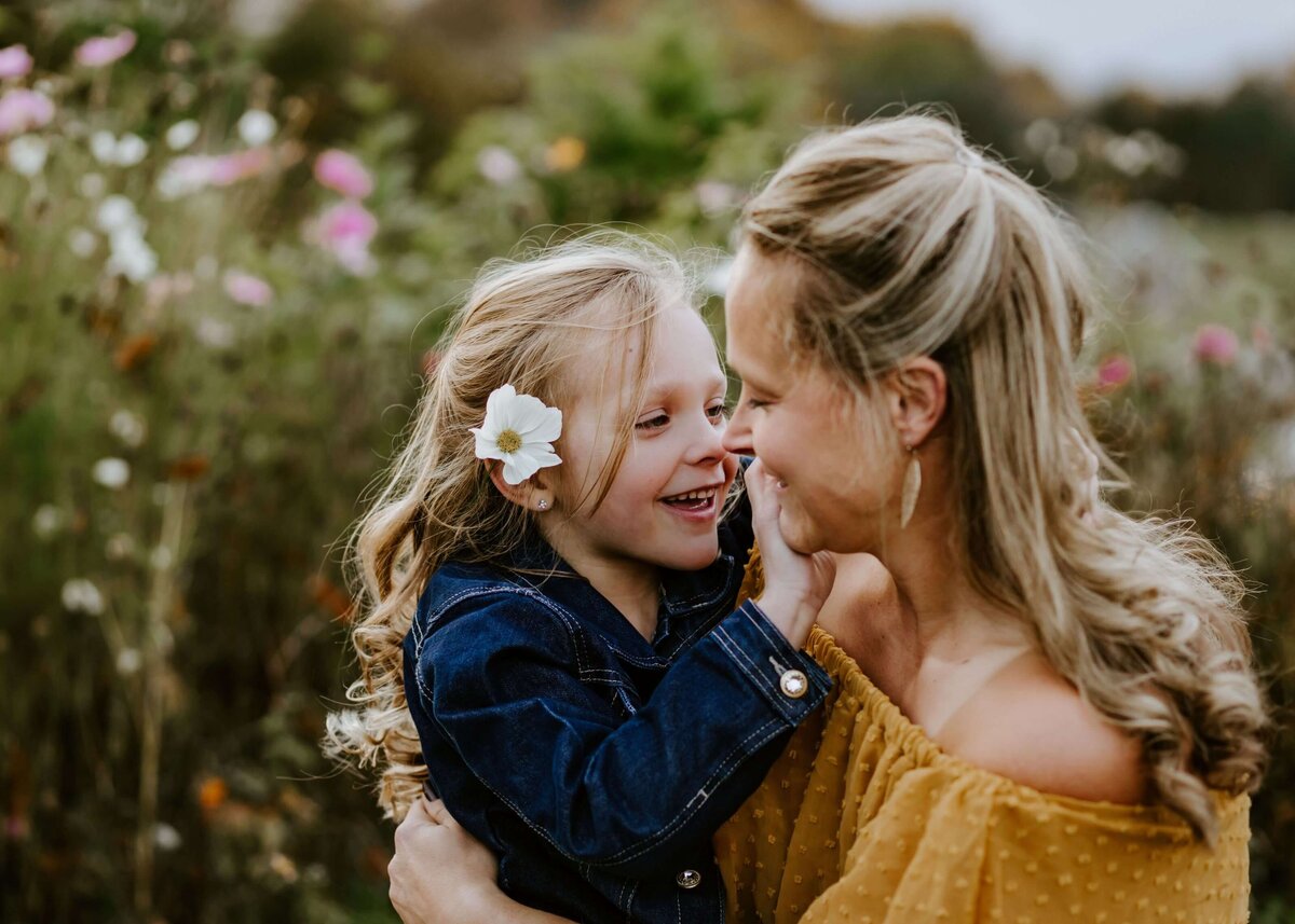 A mother and daughter embracing in a field of flowers, captured by a Pittsburgh family photographer.