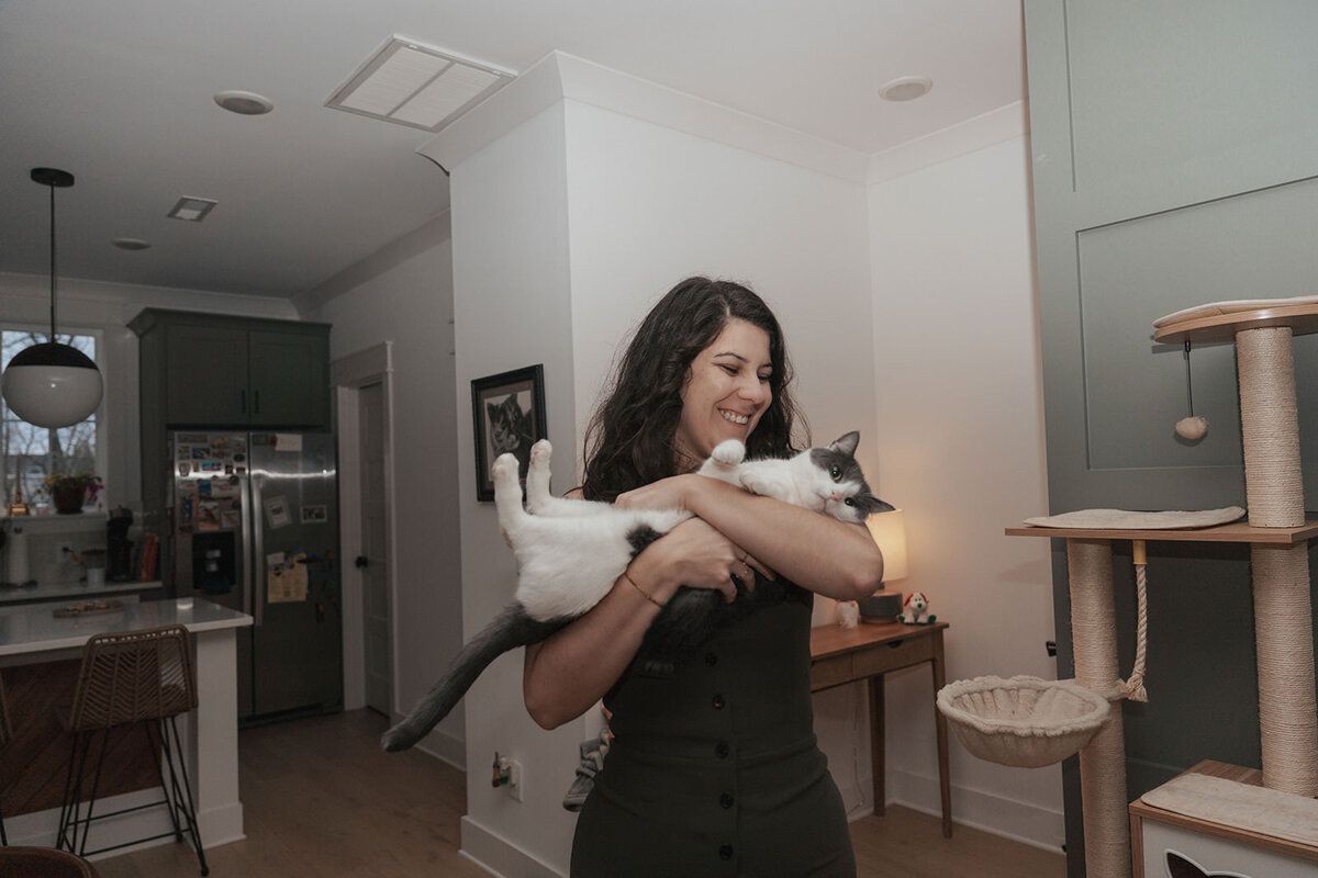 Woman smiles holding her pet cat