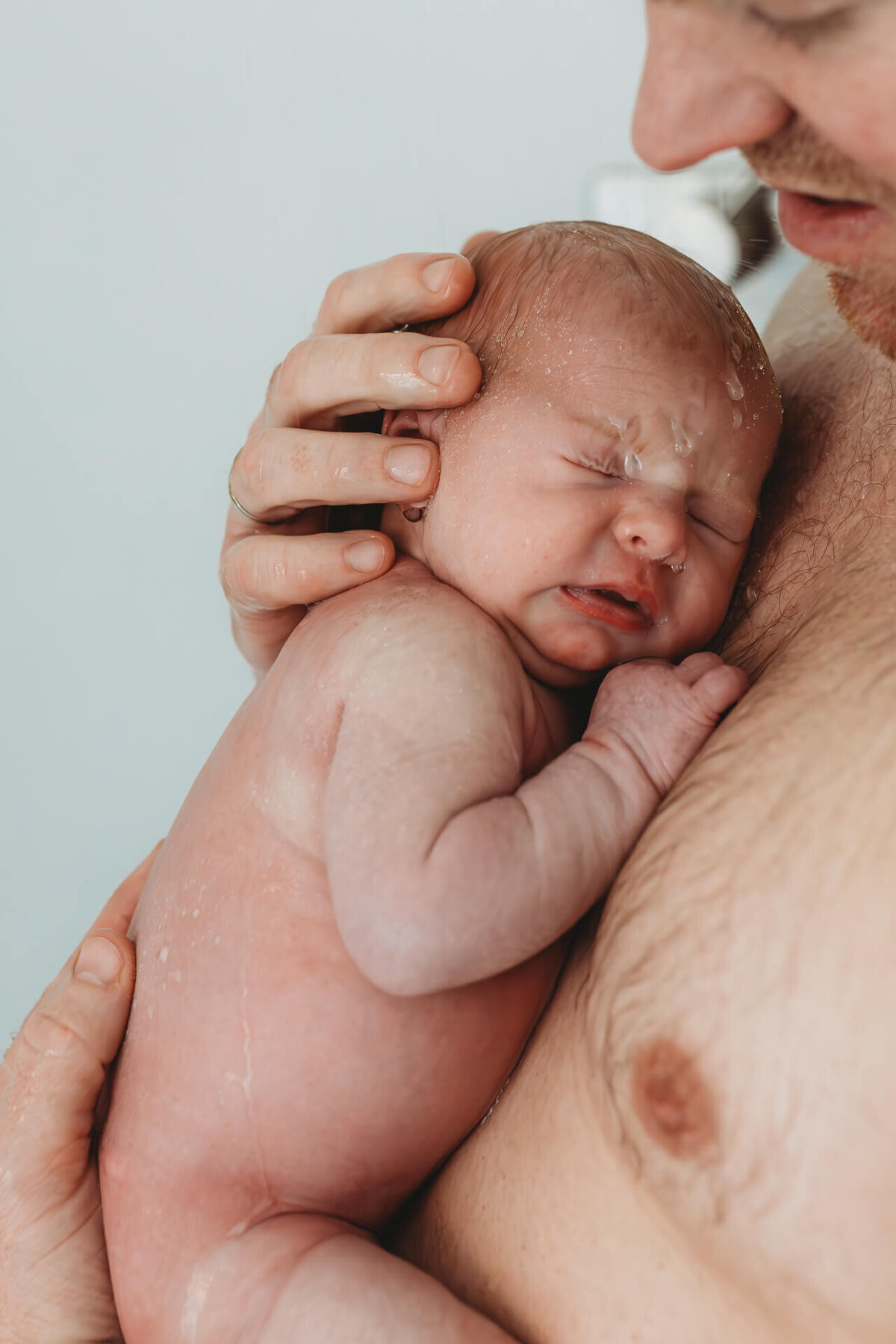 Papa en baby onder de douche tijdens een kraamreportage