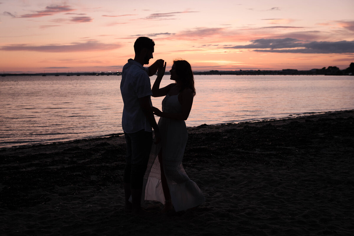 A silhouette of a couple dancing on the beach at sunset