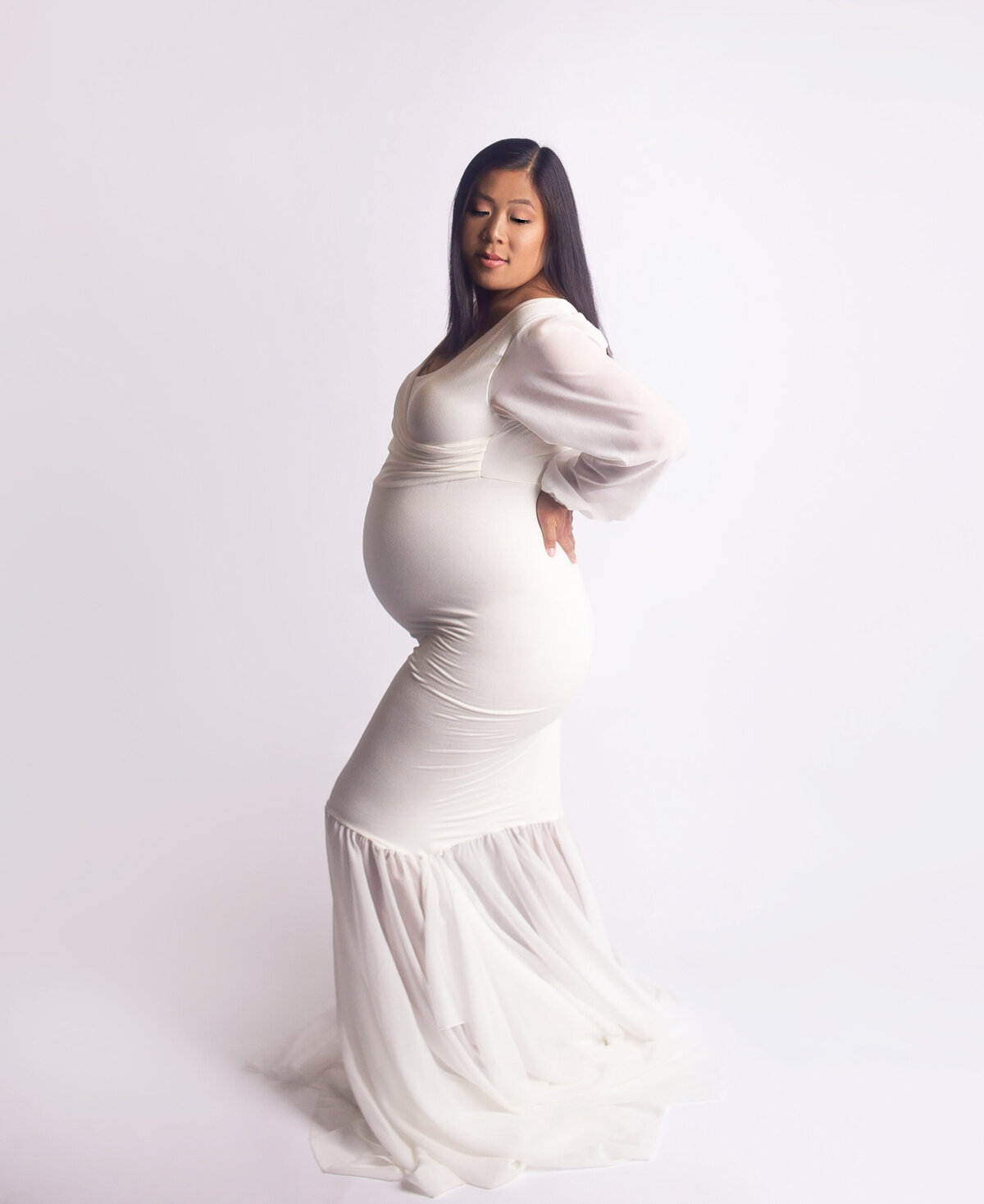 Women wearing white floor length maternity gown  during maternity photoshoot in Franklin tennesse photography studio