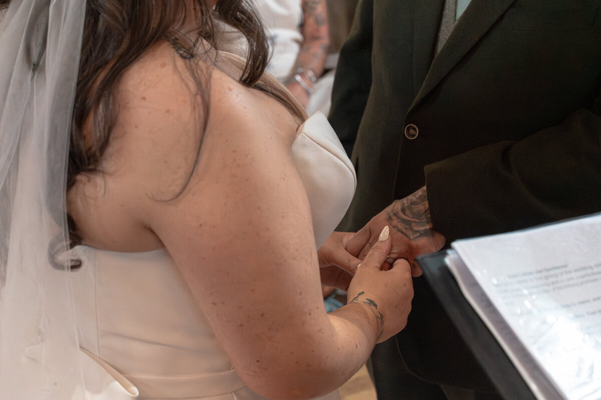 Bride and groom exchanging rings during ceremony in Worsley Court House ceremony room.