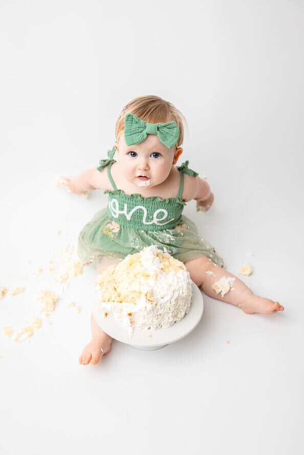 Baby smashes cake all over photo studio.