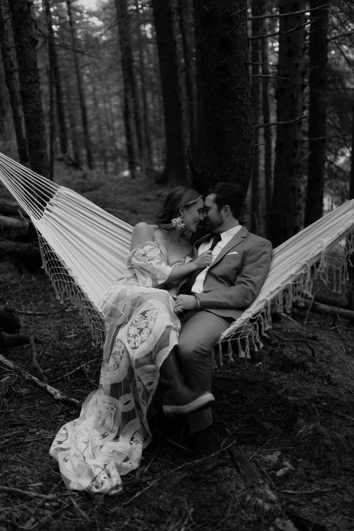 black and white image bride and groom kissing in hammock