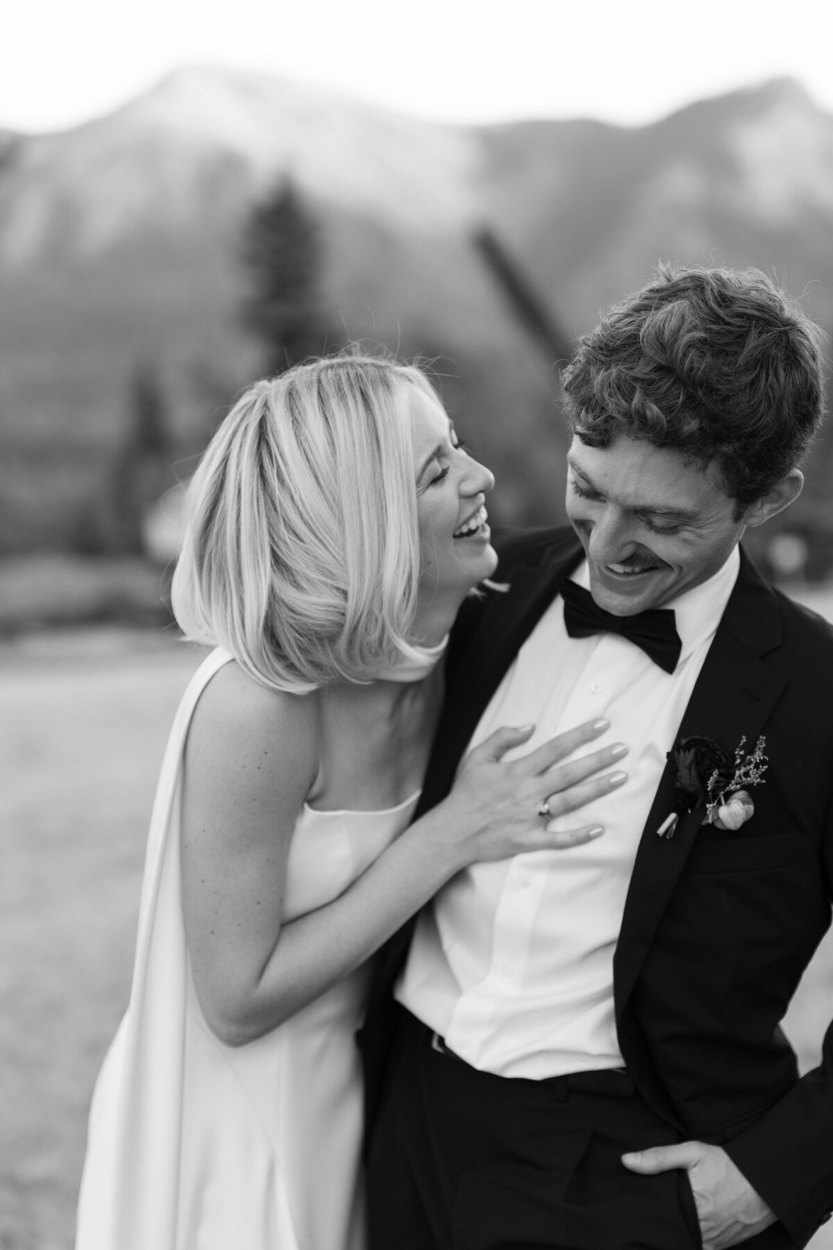 Bride laughing with groom during candid black and white wedding portrait