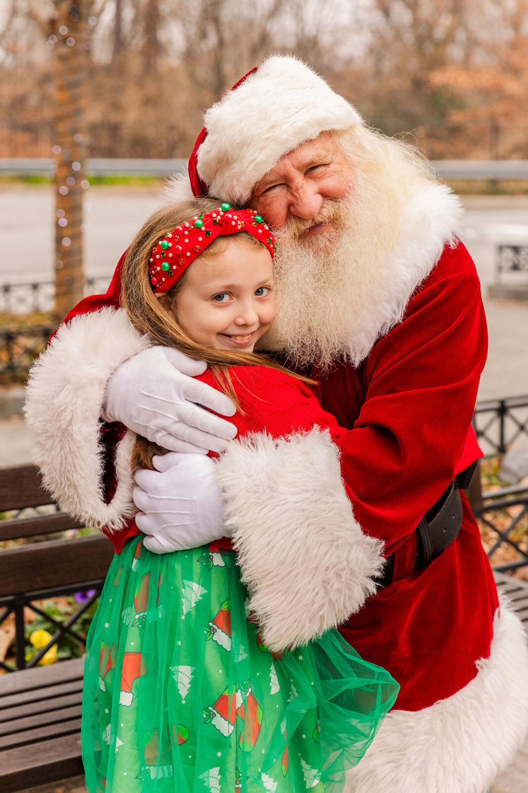 Young girl hugging Santa Claus during holiday event in Atlanta by event photographer Laure Photography