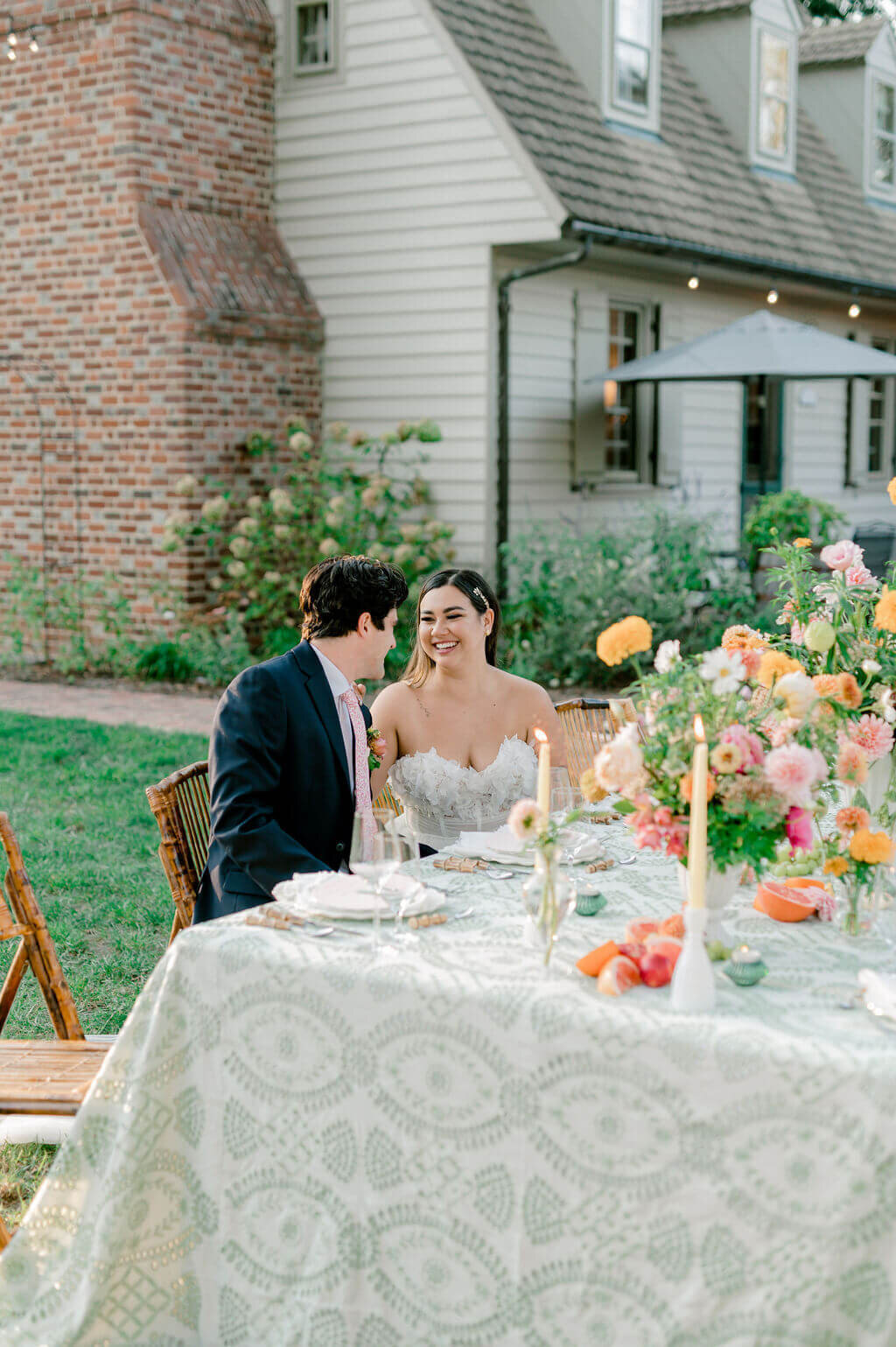couple sitting at a floral reception table on their wedding day 