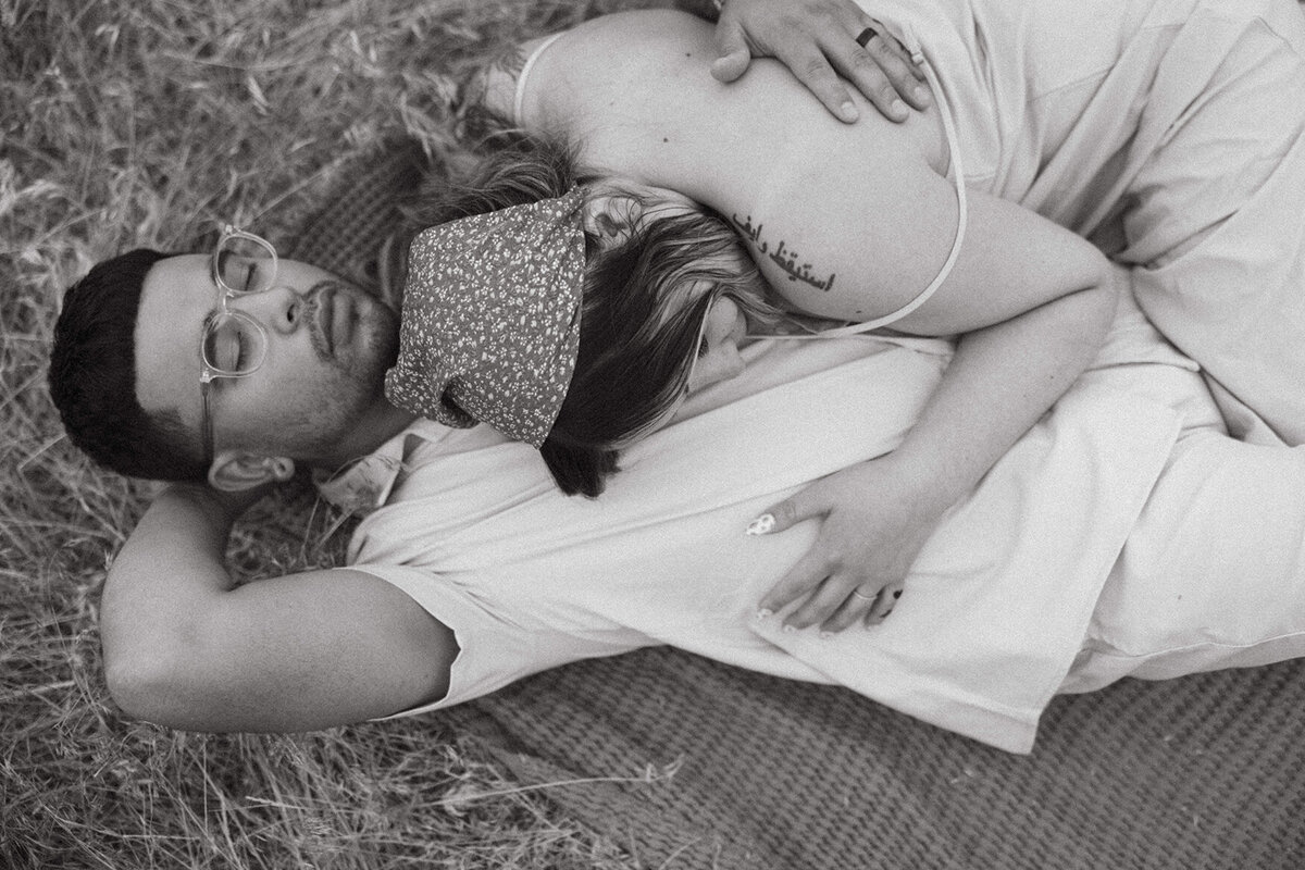 couple lays on grass