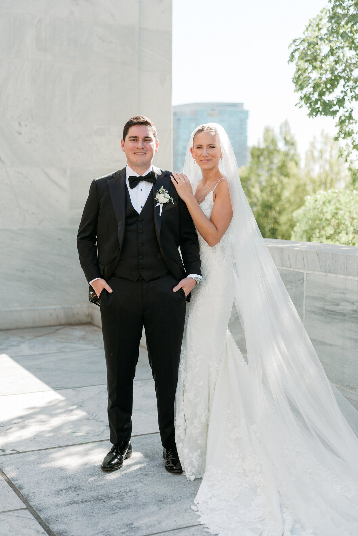 Bride and groom pose in natural light against marble walls, captured by a Philadelphia wedding photographer.