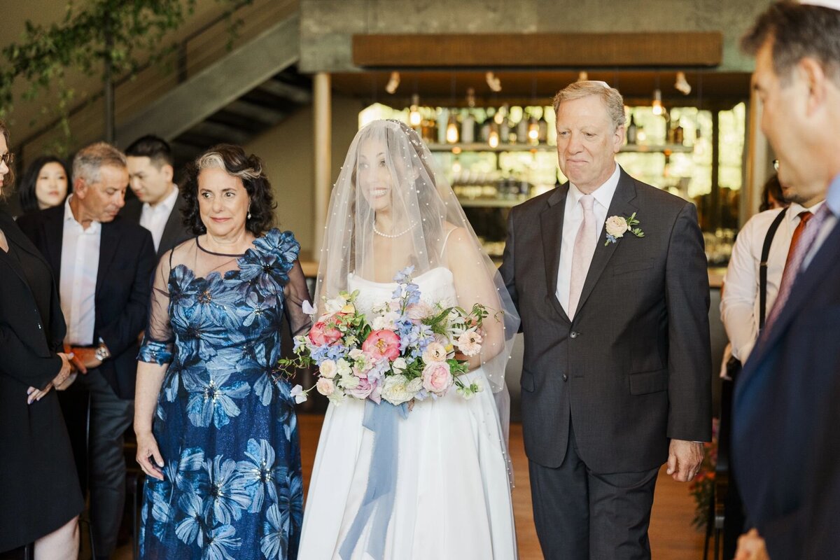 Bride walks up the aisle at The Roundhouse during indoor ceremony