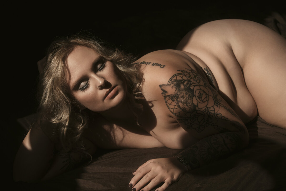 The Delicate Studio Boudoir portrait of a woman on a bed in-studio