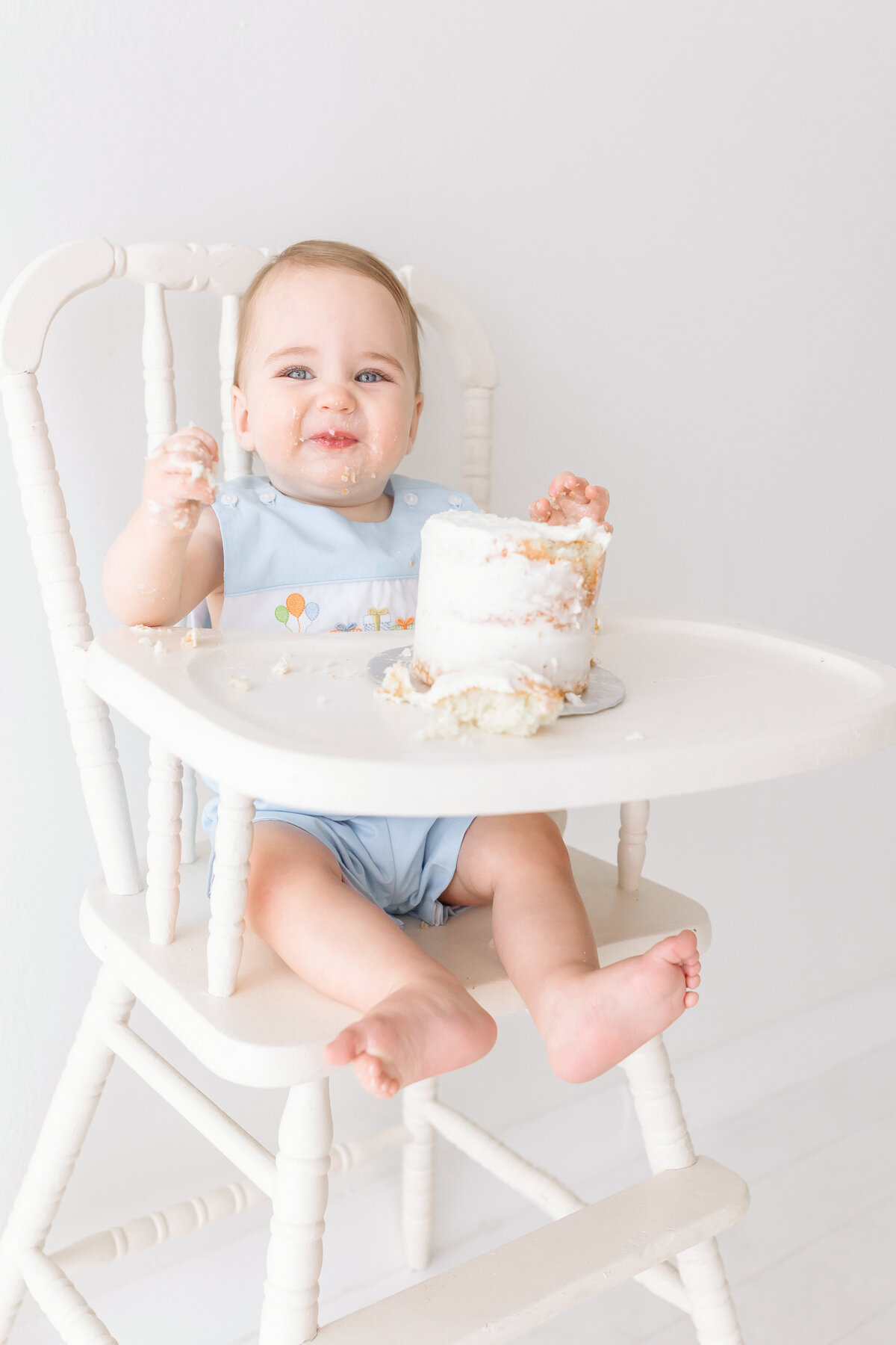 toddler smashing cake smling