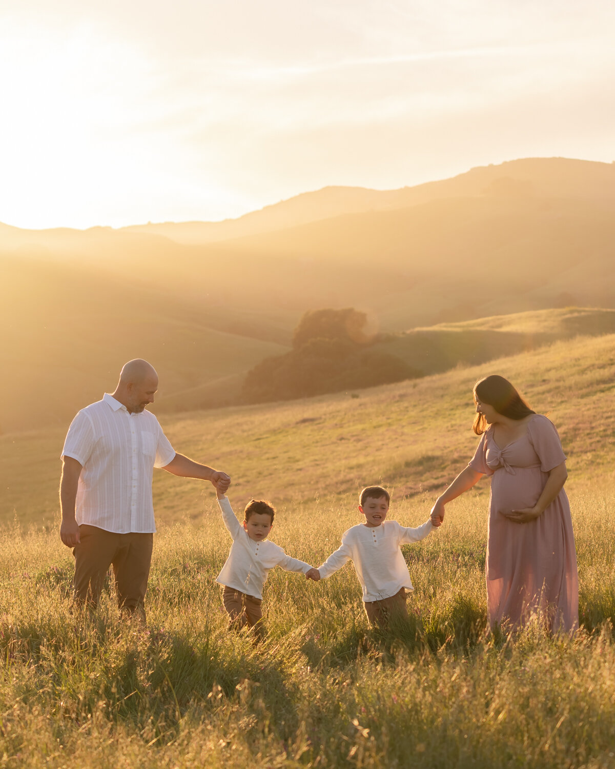 Family photos with couple and two kids baby bump maternity photos in open field golden on the Central Coast in San Luis Obispo