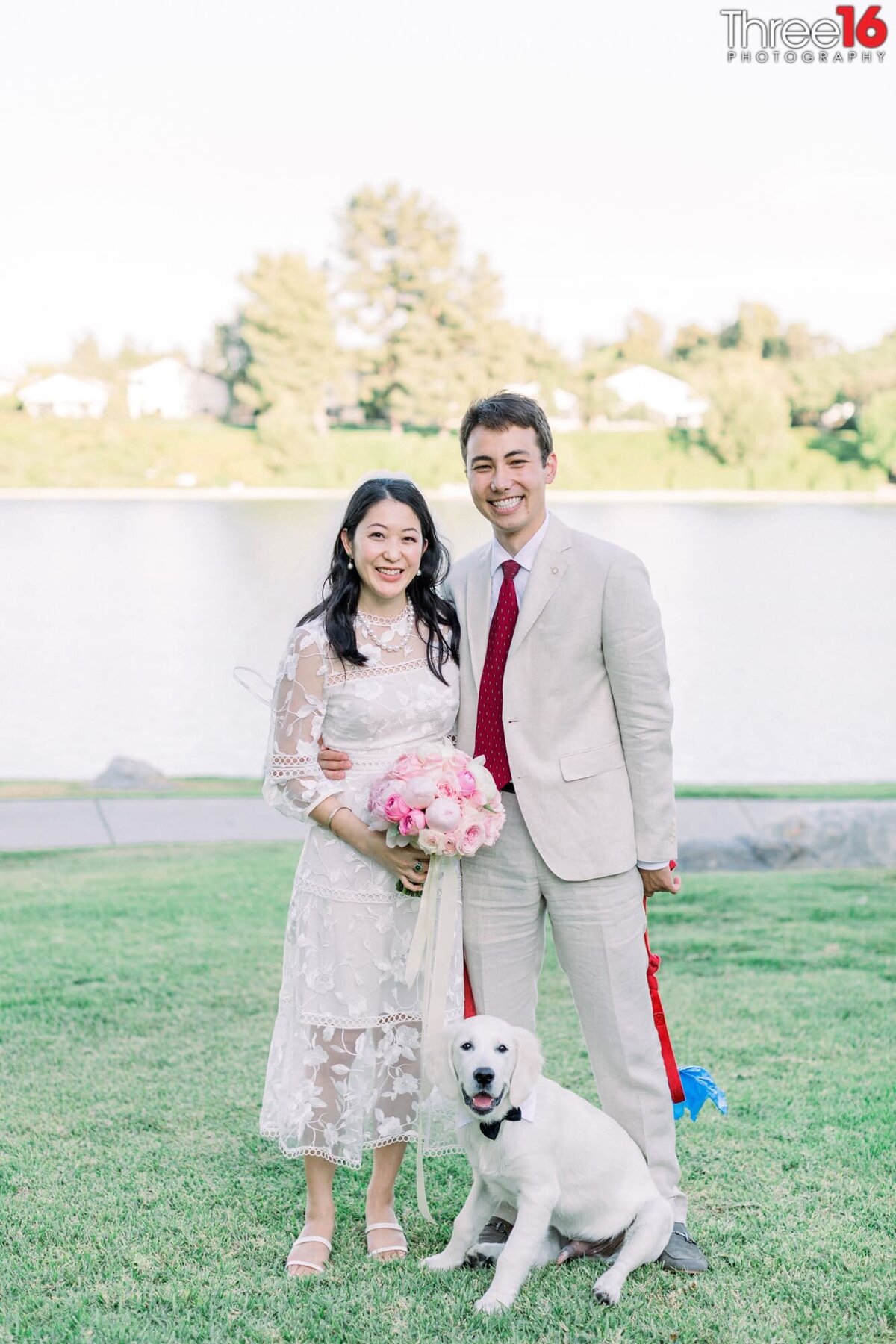 Bride and Groom pose with their little white dog