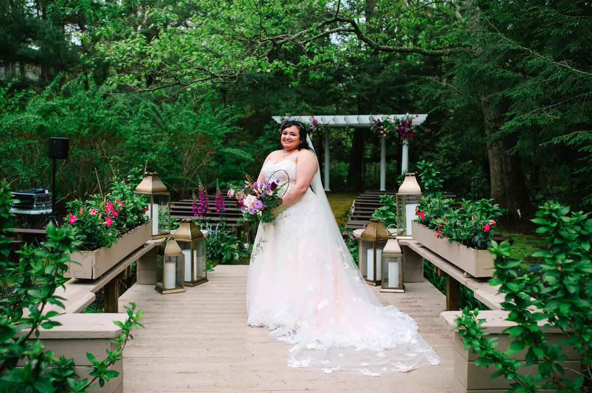 Bride in garden while holding her wedding bouquet