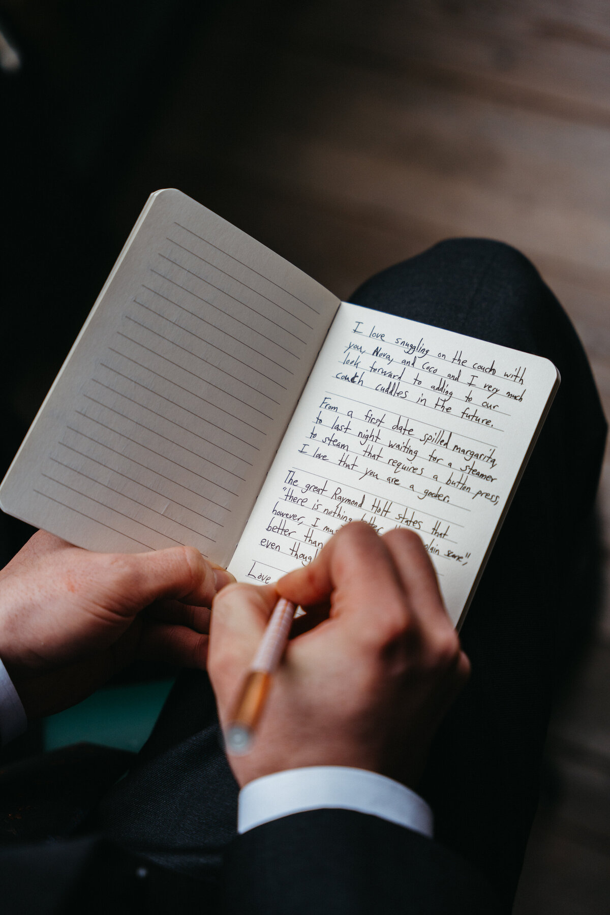 Groom writing vows in notebook before ceremony
