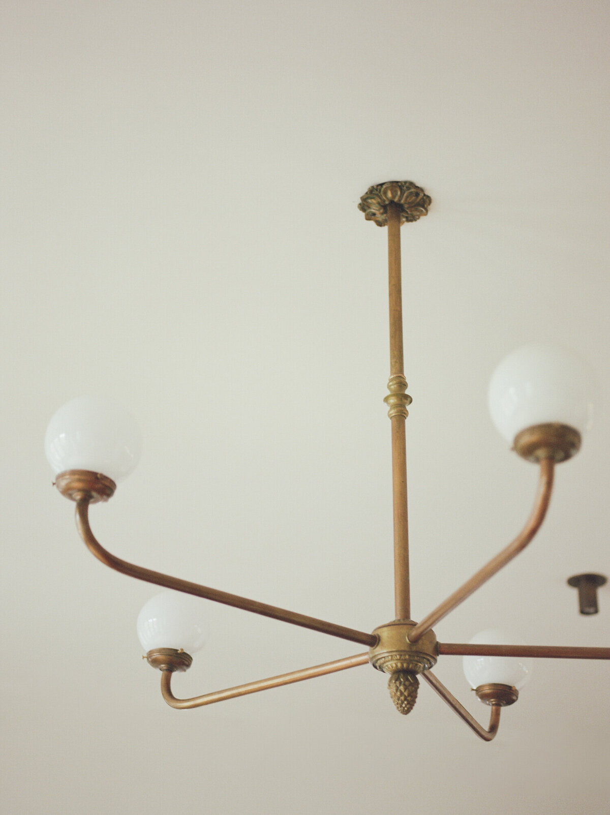 clean warm white ceiling with antique brass simple chandelier, ALEO Detroit branding, web designer
