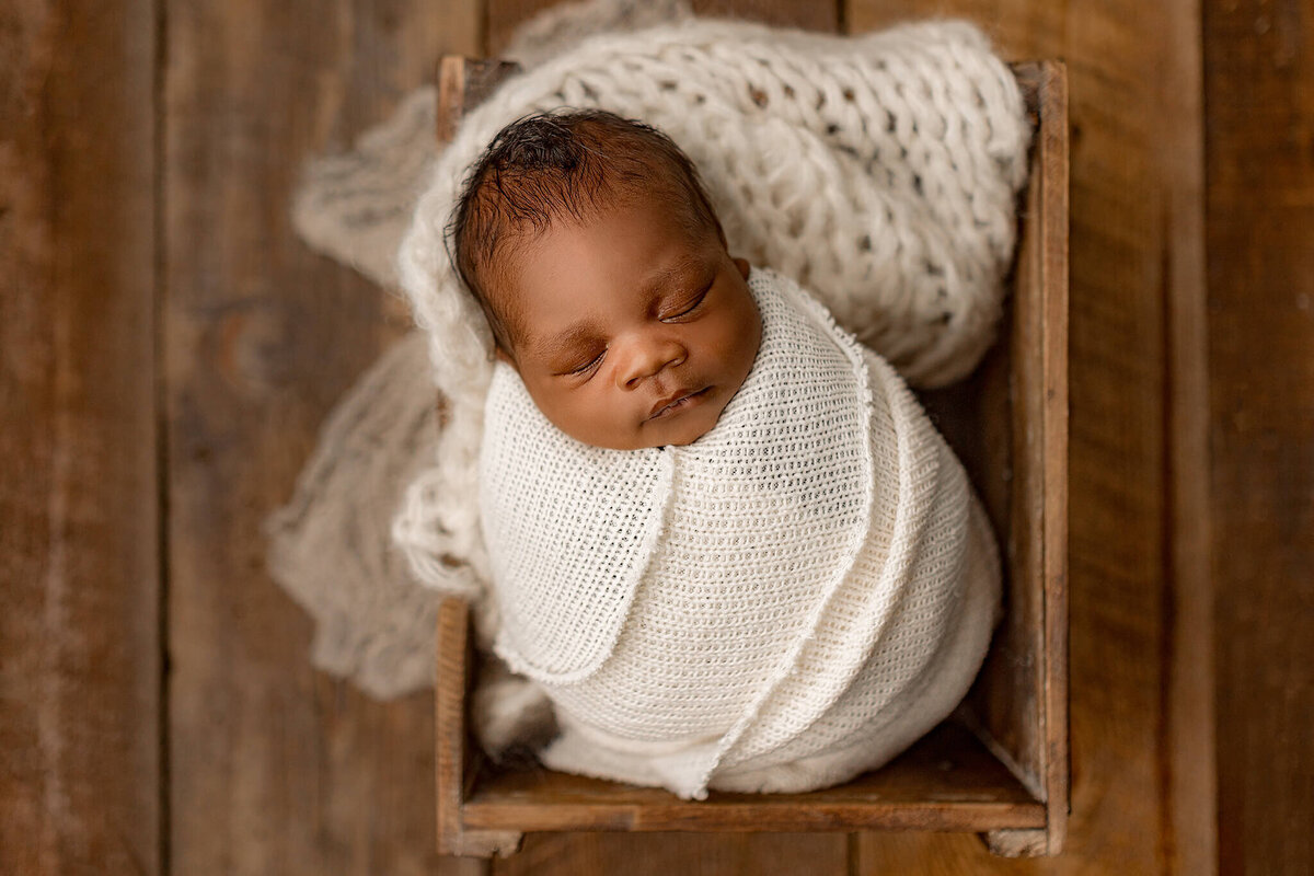 baby swaddled in cream