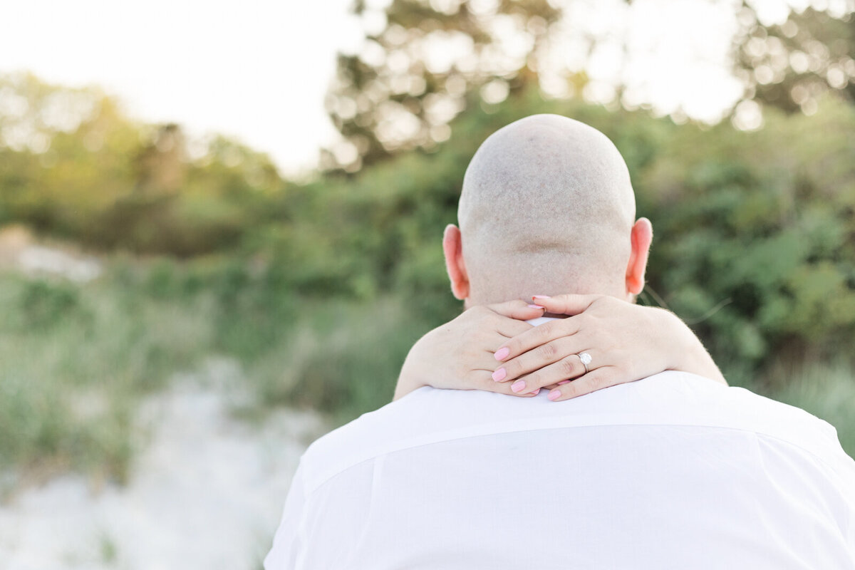 An engaged couple share a moment on a beach in Gloucester