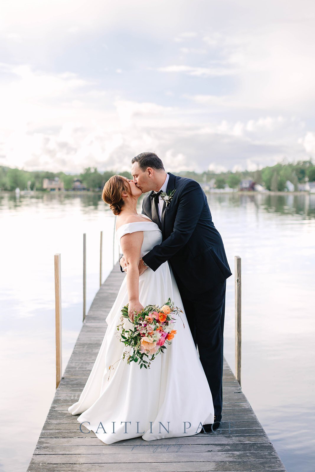 First look with couple kissing on the docks at Mill Falls