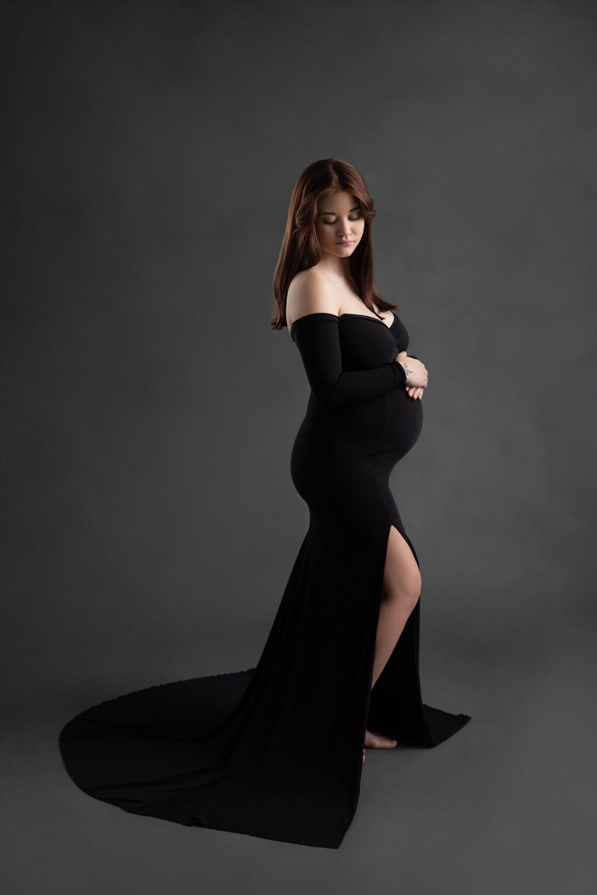 preagnant woman in a black dress with her hands on top of her belly