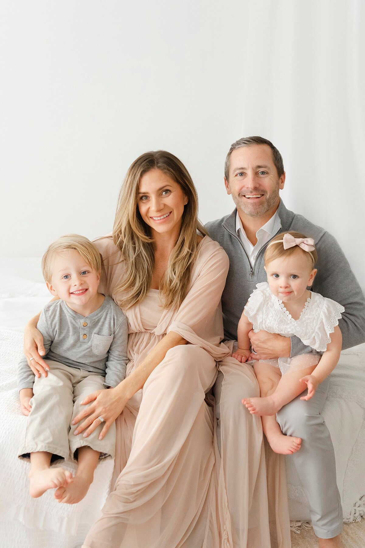 family smiling in studio taken by boston area family photographer​