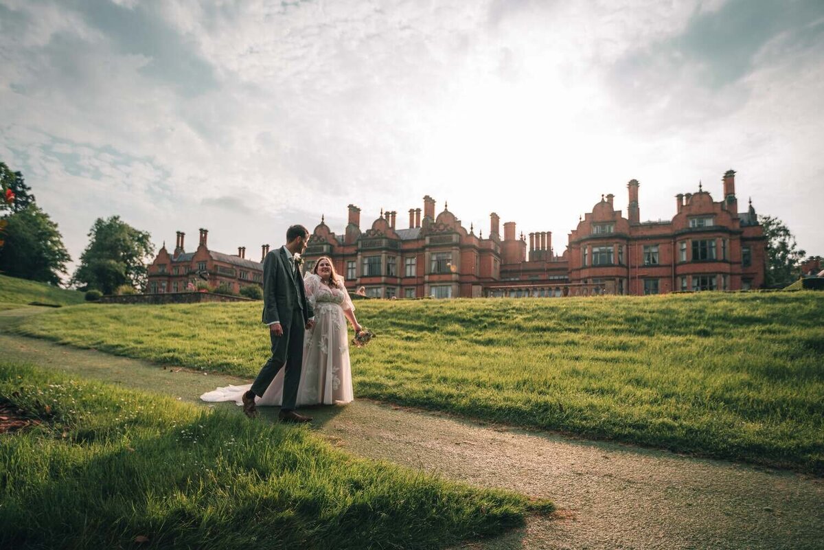 Bride and Groom walk past Welcombe Hotel