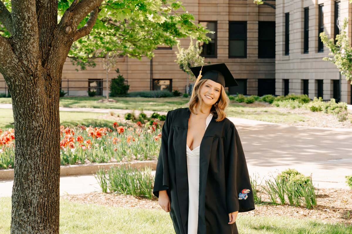 A person in a graduation cap and gown smiling 