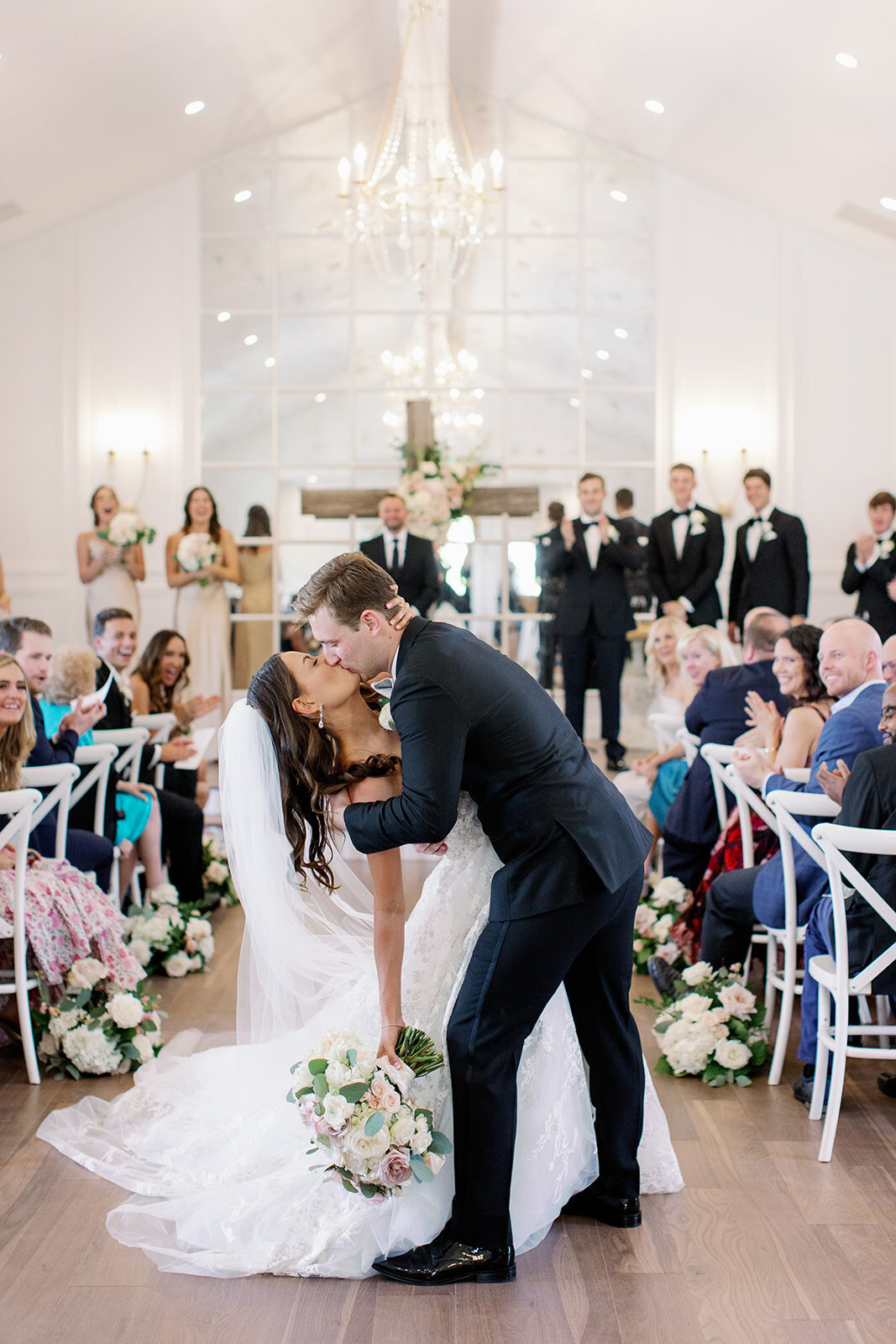 groom dips bride for kiss walking down aisle