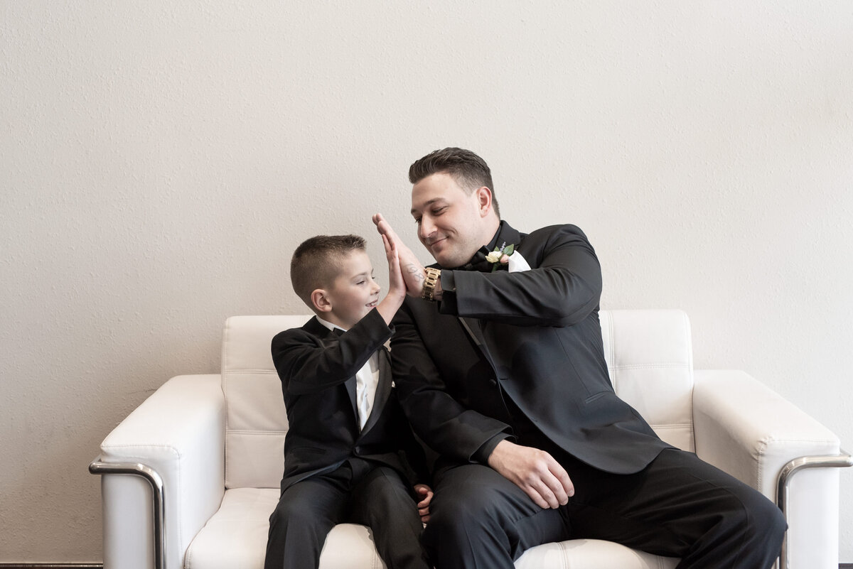 Groom high fives his ring bearer on wedding day