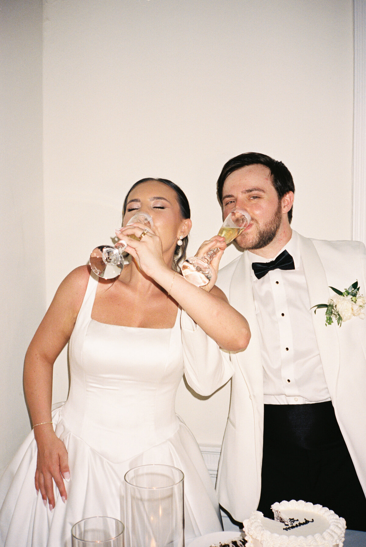 A bride and groom stand drinking their celebratory champagne at their wedding reception in Charleston